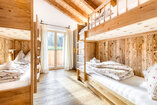 Zweites Schlafzimmer in Chalet 3 mit zwei Etagenbetten in Nischen aus Altholz