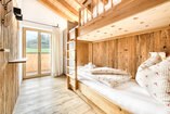 Zweites Schlafzimmer in Chalet 2 mit Etagenbett in einer Nische aus Altholz