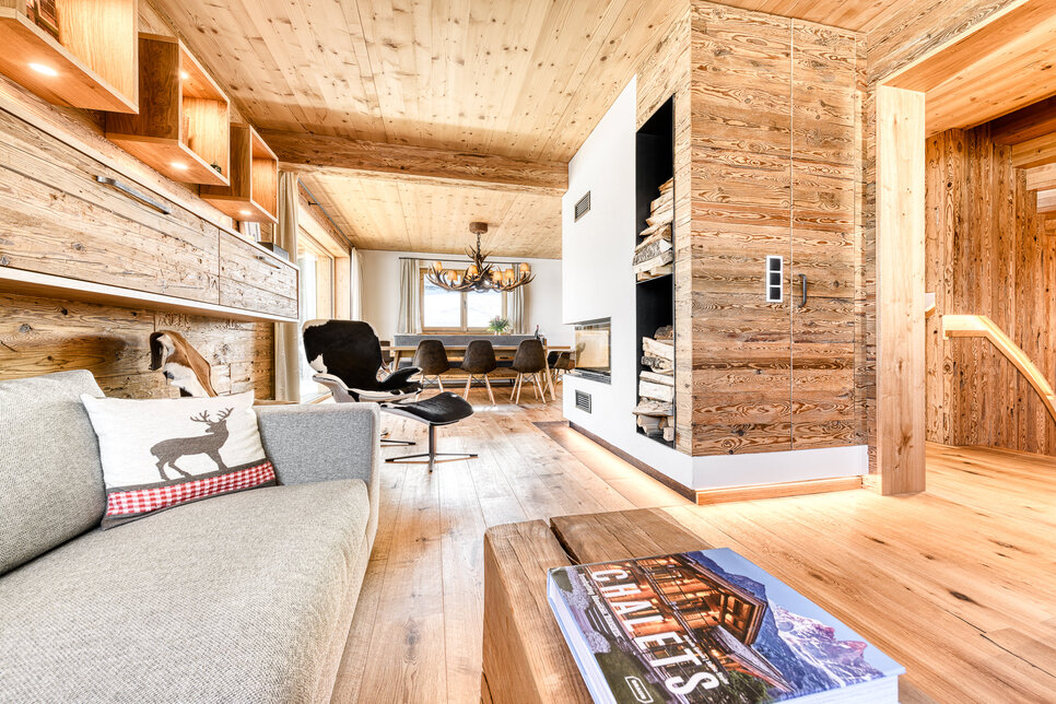 Wohnraum in Chalet 1 mit Kaminofen aus Altholz, dahinter der Essbereich