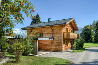 Chalet 1, Seitenansicht mit Carport Chalet 1 von der Seite, links der Carport, dahinter die Berge