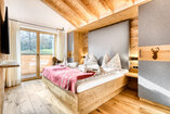 Zweites Schlafzimmer in Chalet 1 mit Doppelbett und Sitzbank