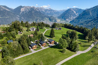 Die Tschengla und der Blick ins Tal Luftaufnahme der Tschengla mit den drei Chalets, darunter das Tal und gegenüber die Berge