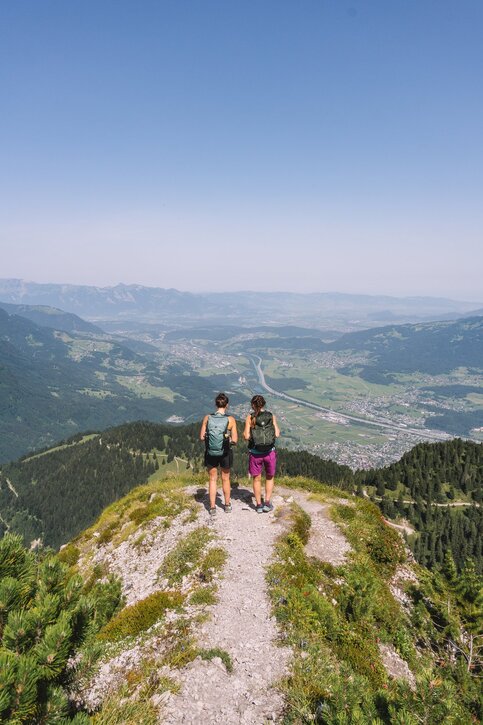 Auf die Mondspitze, mit Blick ins Rheintal. Foto: Robert Bohnke / Alpenregion Bludenz Tourismus Zwei Wanderinnen am Grat der Mondspitze, tief darunter das Rheintal